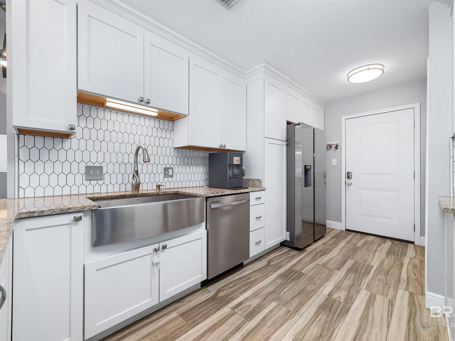 Renovated kitchen with white shaker cabinets, granite countertops, and stainless appliances