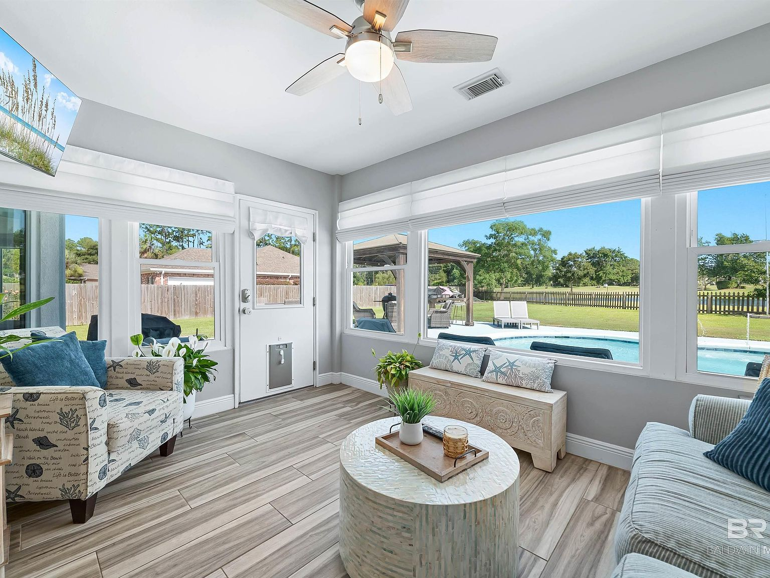 Enclosed sunroom with views of pool and golf course