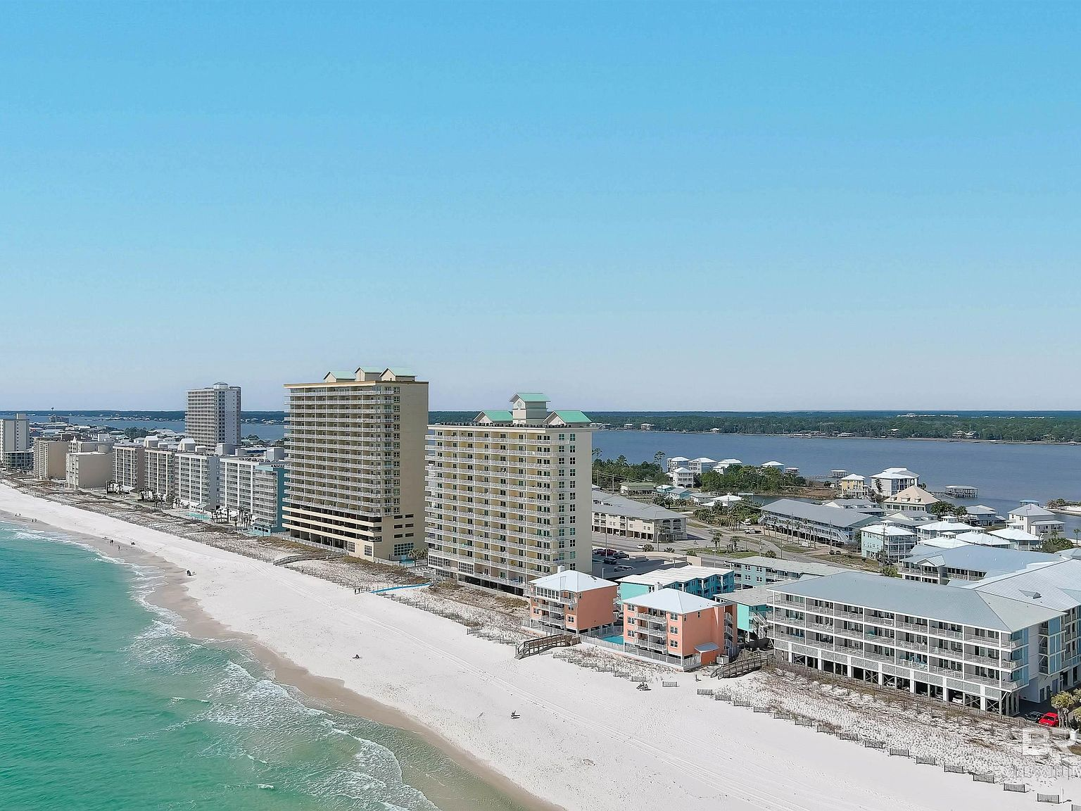 Aerial view looking down the Alabama Gulf Coast beachfront showing the shoreline and coastal development