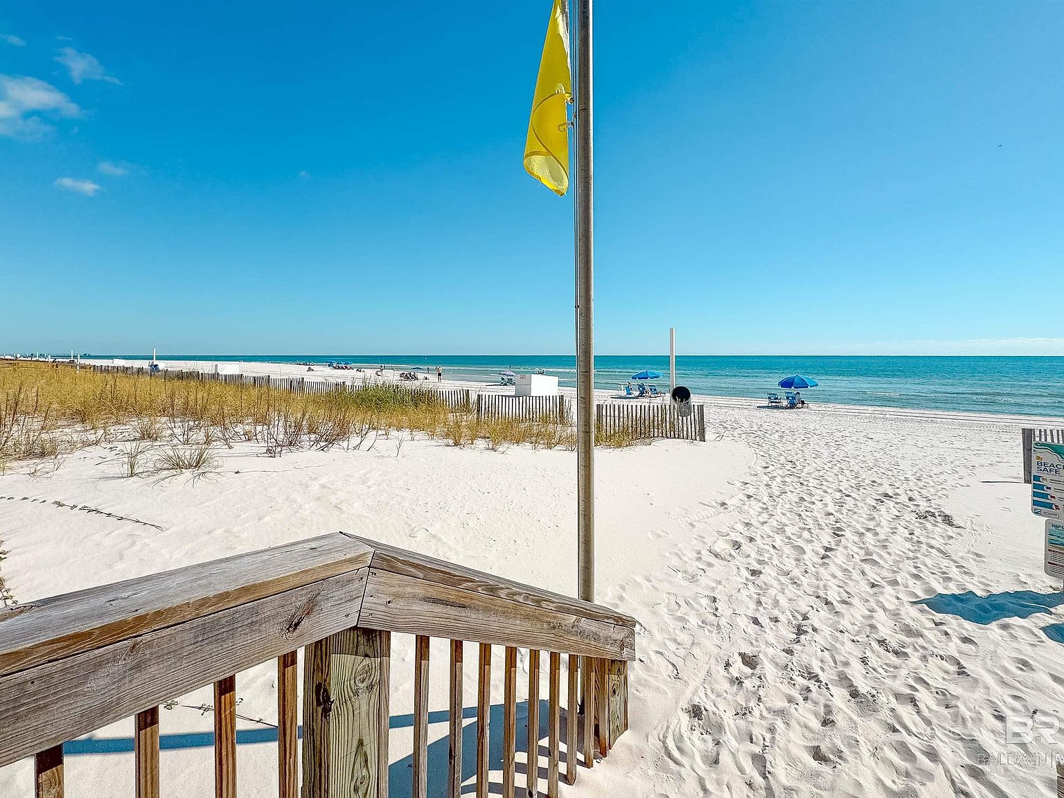 Sandy beach access path leading to the Gulf Shores shoreline between coastal dunes