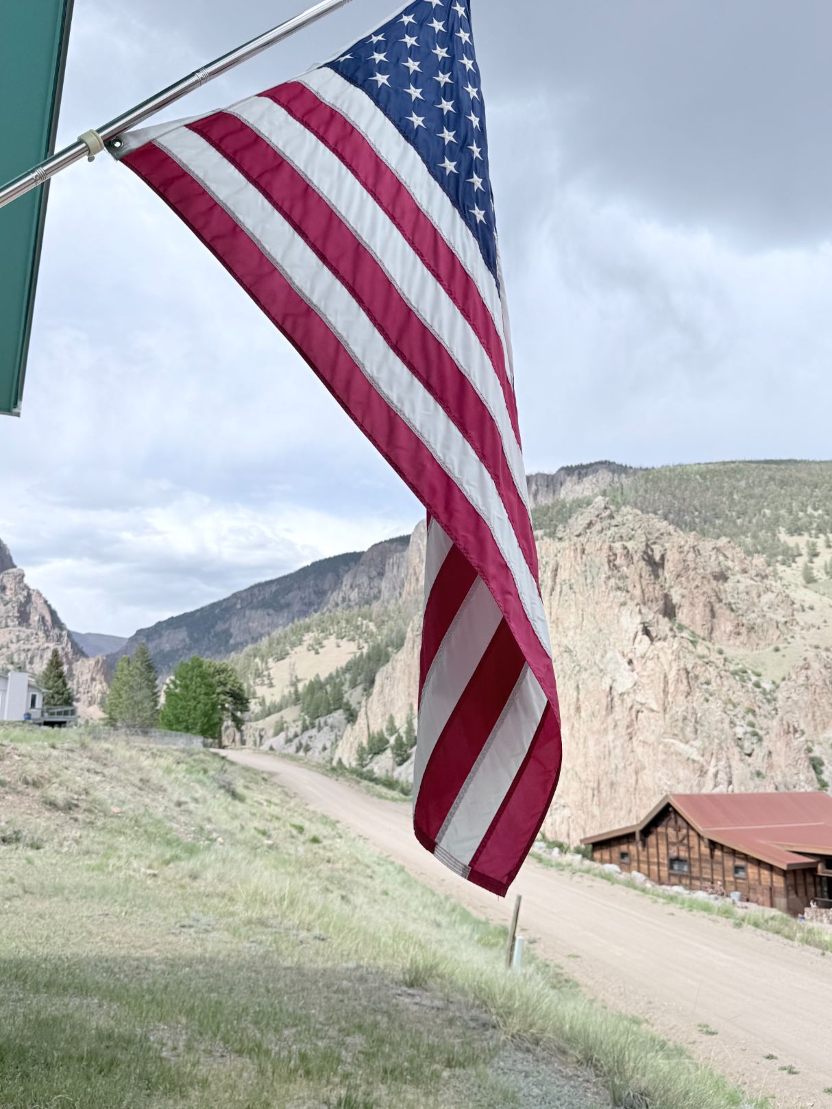 american flag hanging from home with view of mountains behind