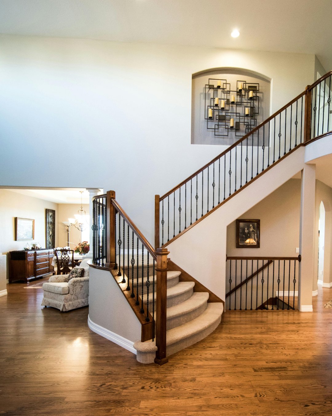 Interior of a luxury home featuring a curved staircase, open-concept layout, natural light, and architectural details.