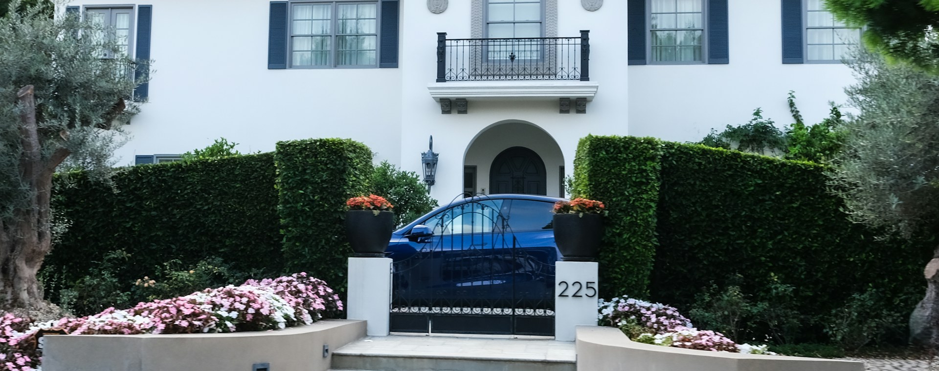 A suburban home exterior with a parked car in front