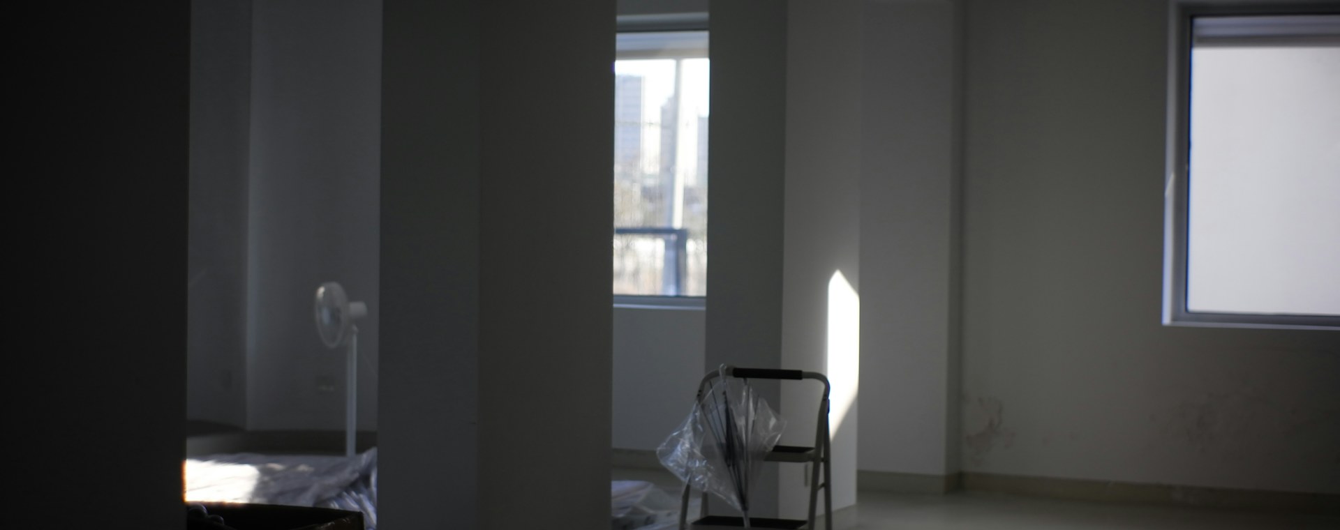 Sunlight streaming into an empty room through a large window