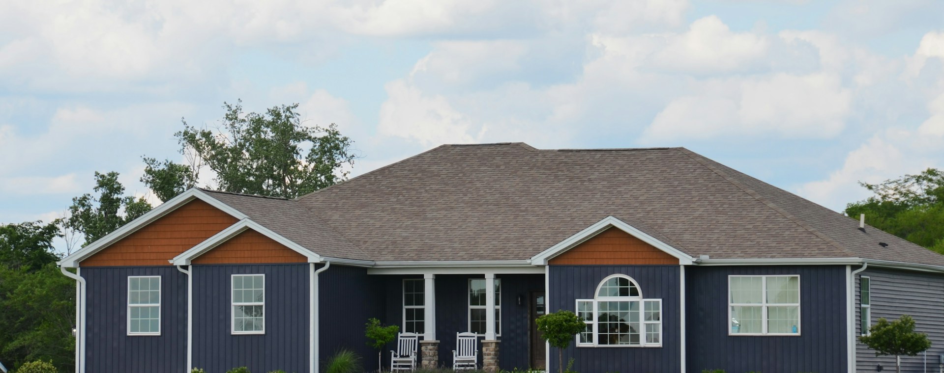 A single-story home with a covered porch and green lawn