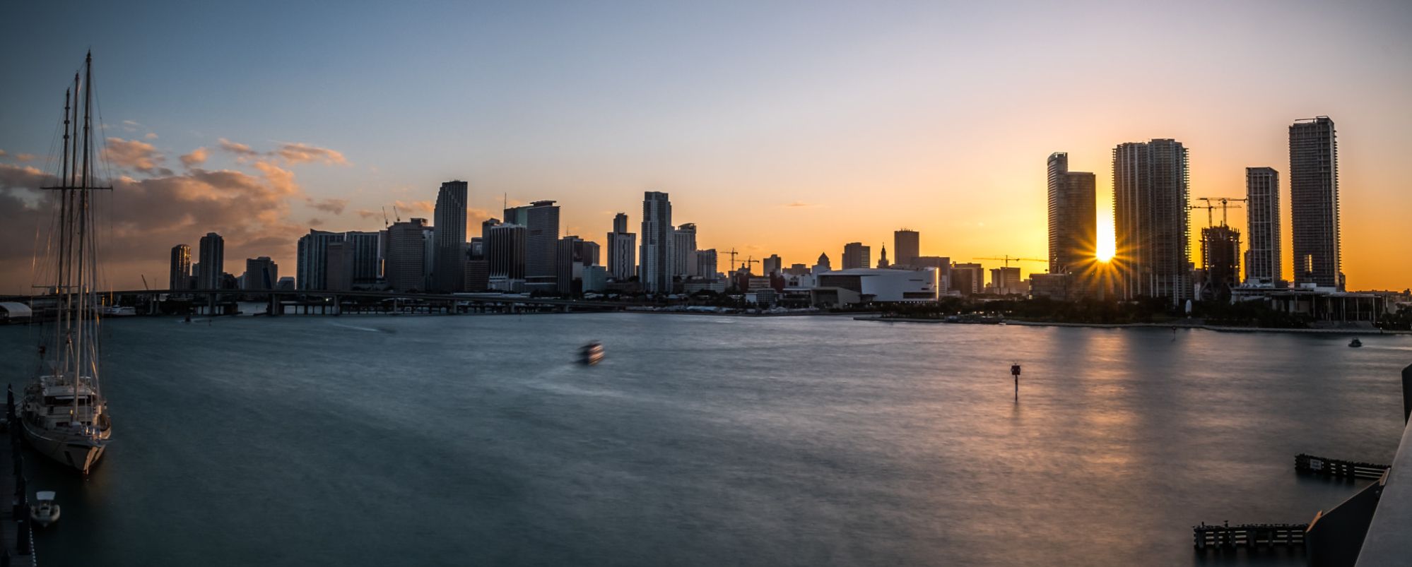 Downtown Miami skyline at sunset reflecting over Biscayne Bay — South Florida real estate market backdrop July 2025