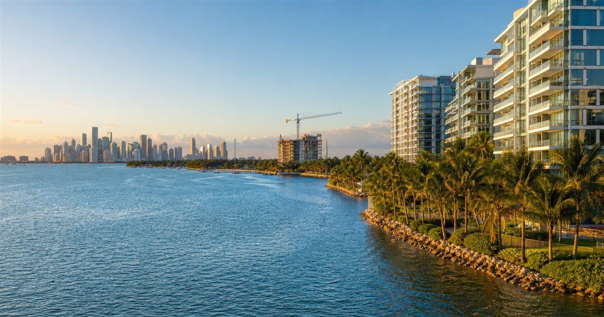 Golden-hour Biscayne Bay waterfront condos near Coconut Grove with Miami skyline views, representing Miami real estate news, condo ownership costs, mortgage rates, and South Florida development.