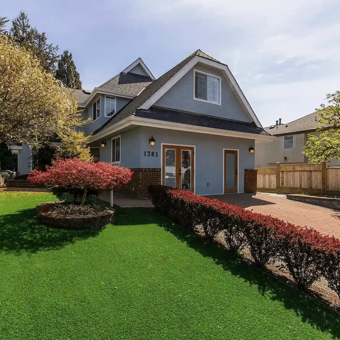 Residential house with green lawn and landscaped shrubs