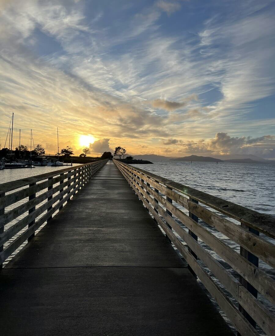 Wooden fishing pier stretching into the Gulf of Mexico at golden sunset