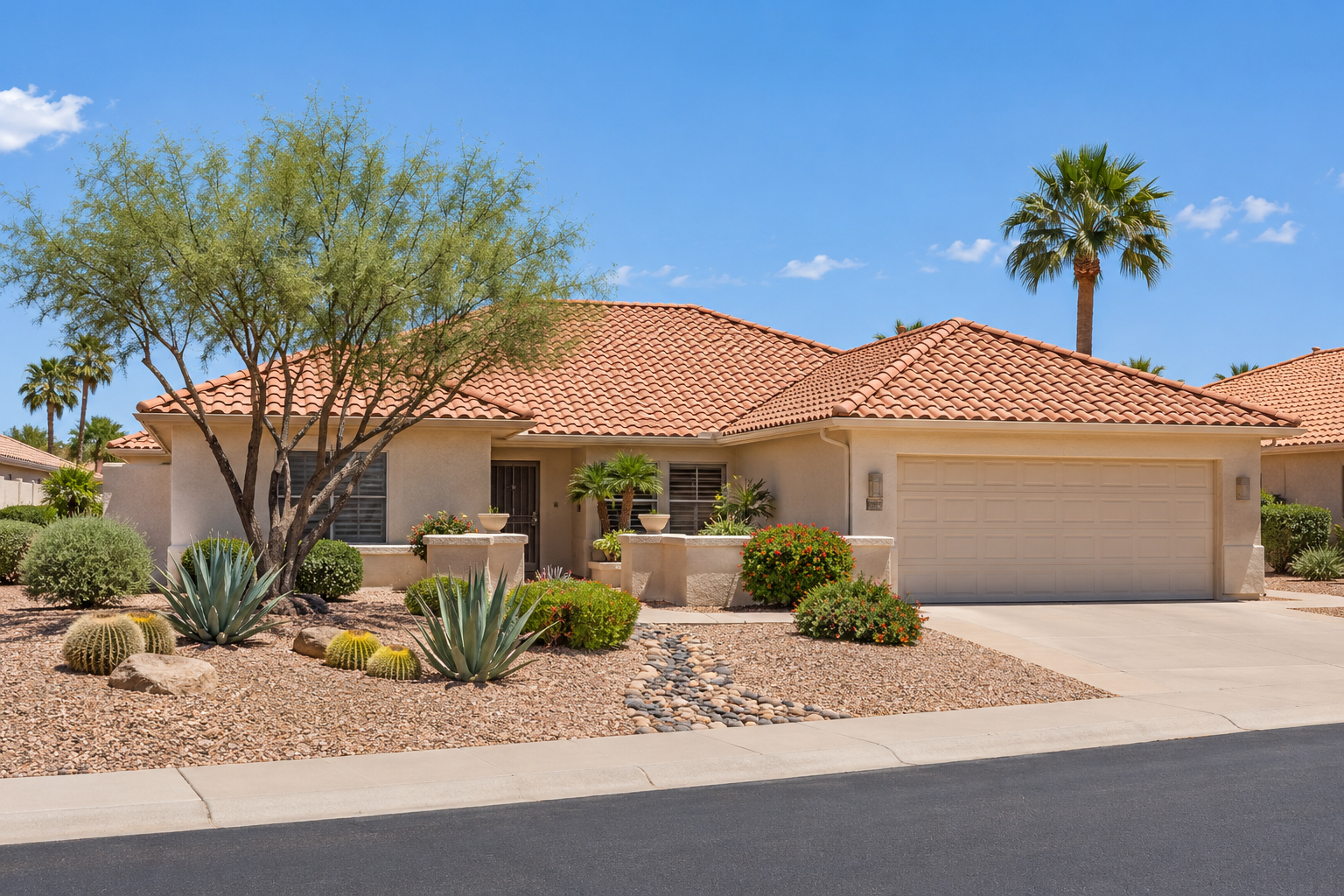 Sun City West home with a tile roof and desert landscaping
