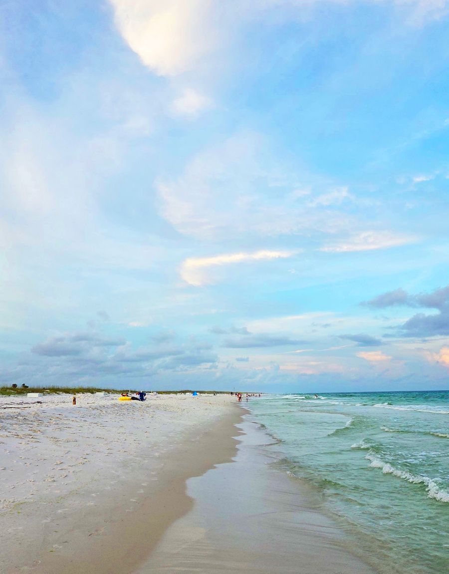 A stretch of white sand beach under a clear blue sky