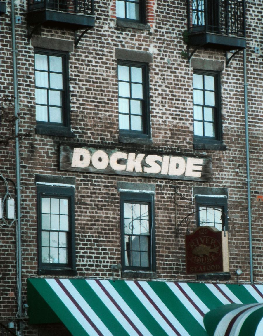 A brick storefront facade with a vintage awning on a historic downtown block
