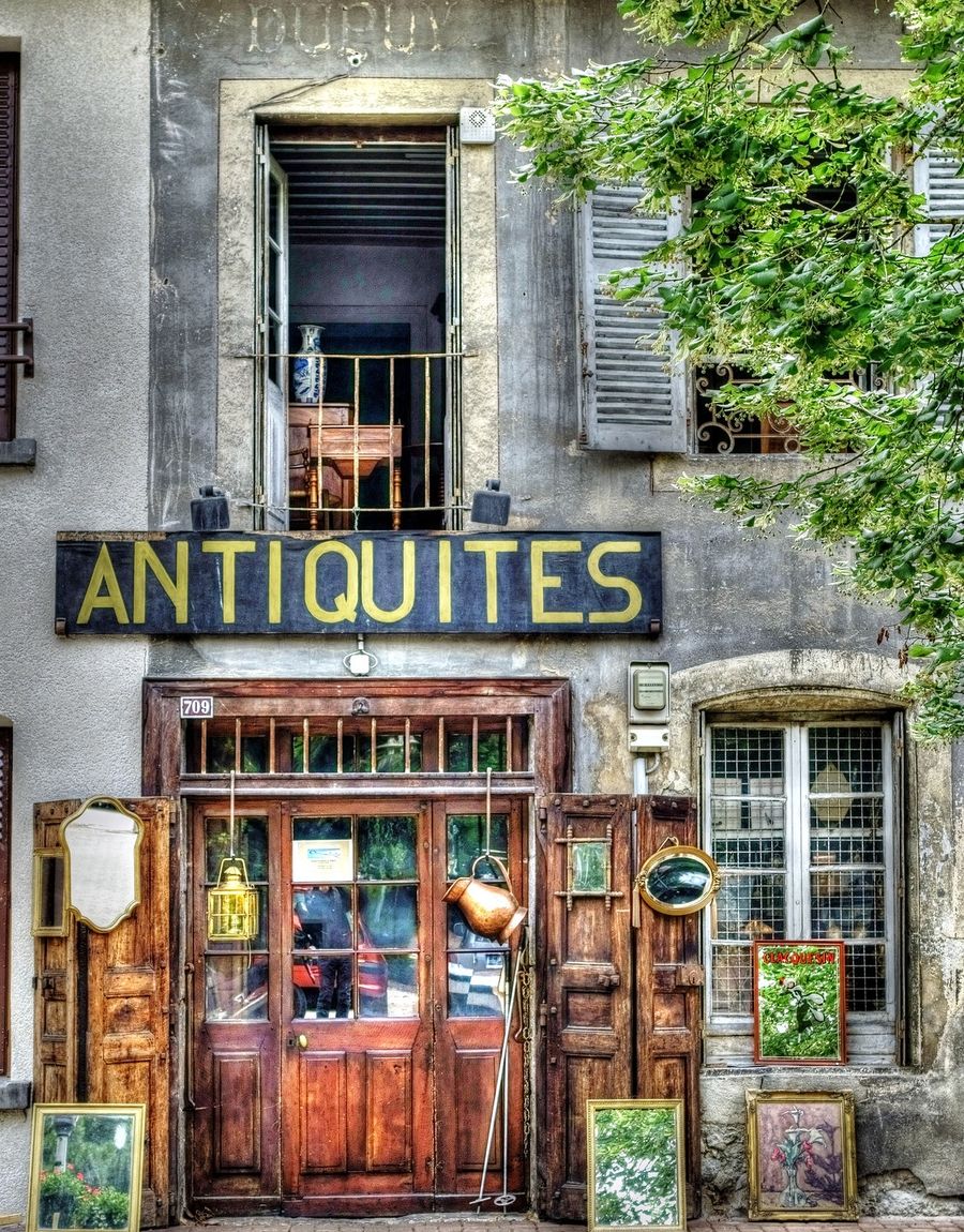 An antique shop storefront with vintage decor on a small-town street