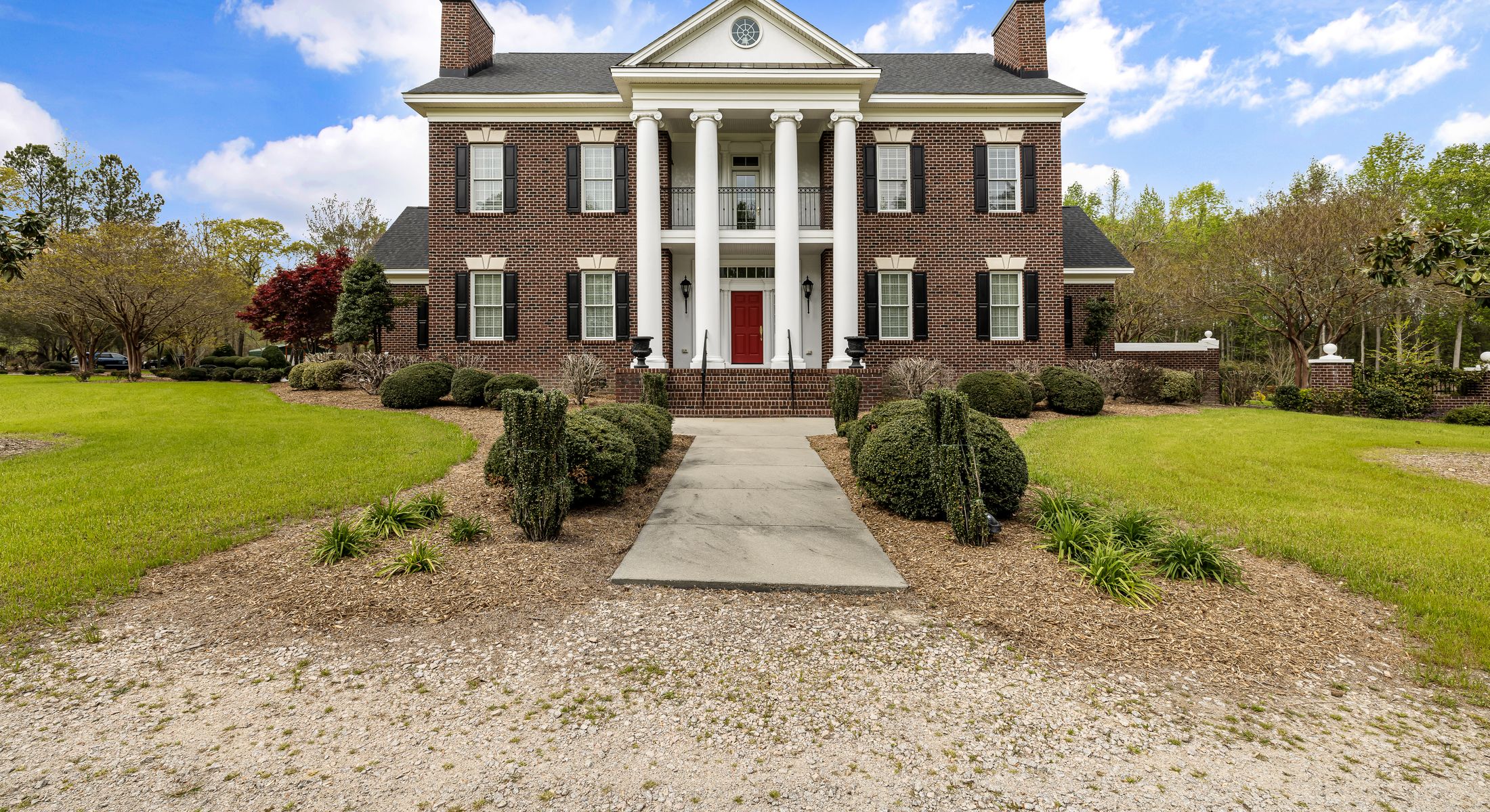 A stately columned estate surrounded by mature Southern landscaping