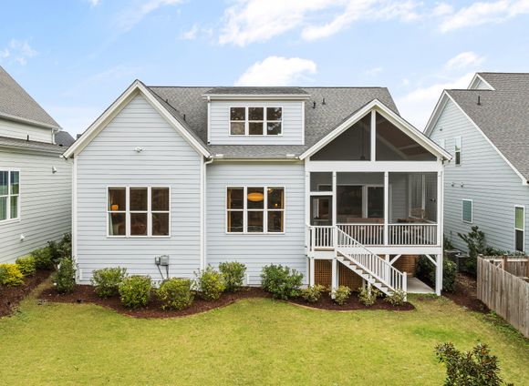 A newly built white farmhouse-style home with a lawn