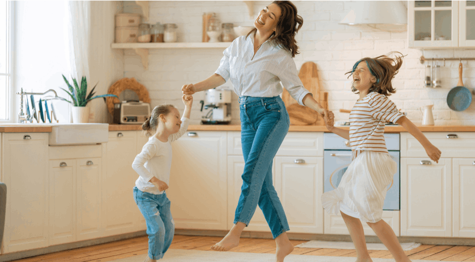 mom and daughters dancing in the kitchen
