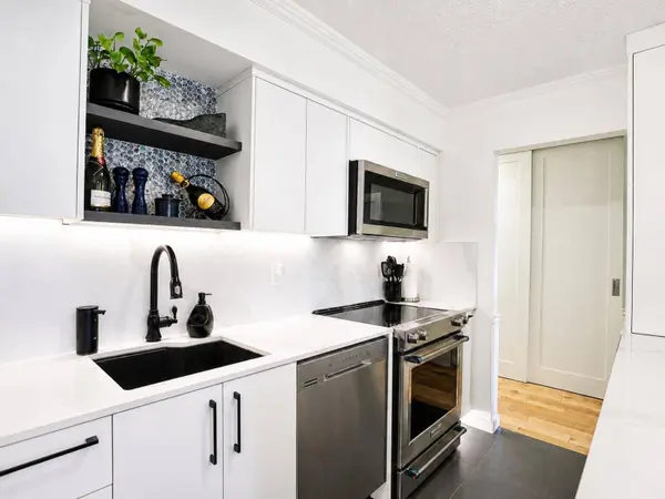 Custom renovated kitchen with large quartz island, bar seating, full-height cabinetry, stainless steel appliances and exceptional storage.