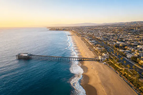Aerial view of the Orange County coastline and pier at golden hour