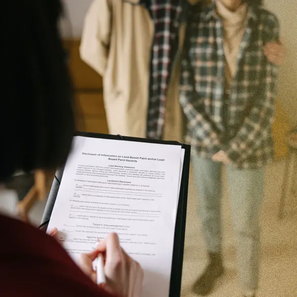 Homeowners reviewing and signing real estate documents with an agent during a home selling consultation.