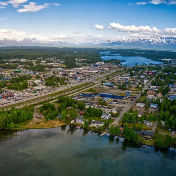 Aerial view of Wasilla Alaska with residential neighborhoods, lakes, and snow-capped mountains in the background