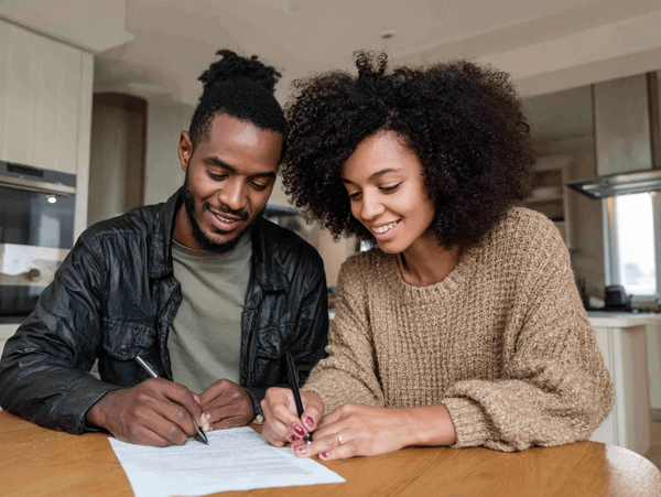 Young couple signing listing documents