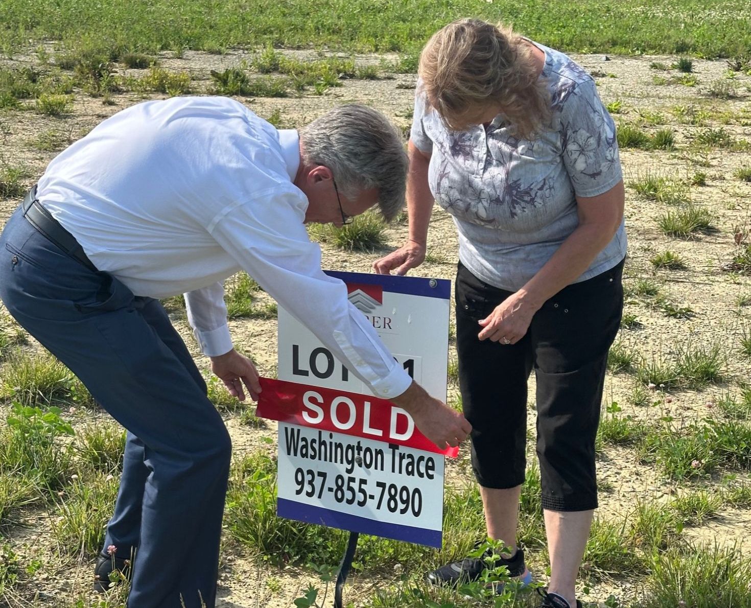 David and Sandy putting a "Sold" sticker on a lot in Centerville, Ohio.