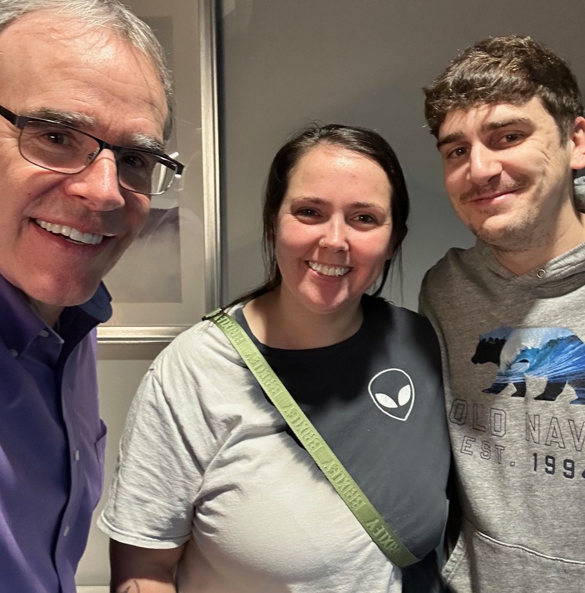 David Campbell, realtor, stands next to both Chris and McKenzie as they all face towards the camera, smiling.