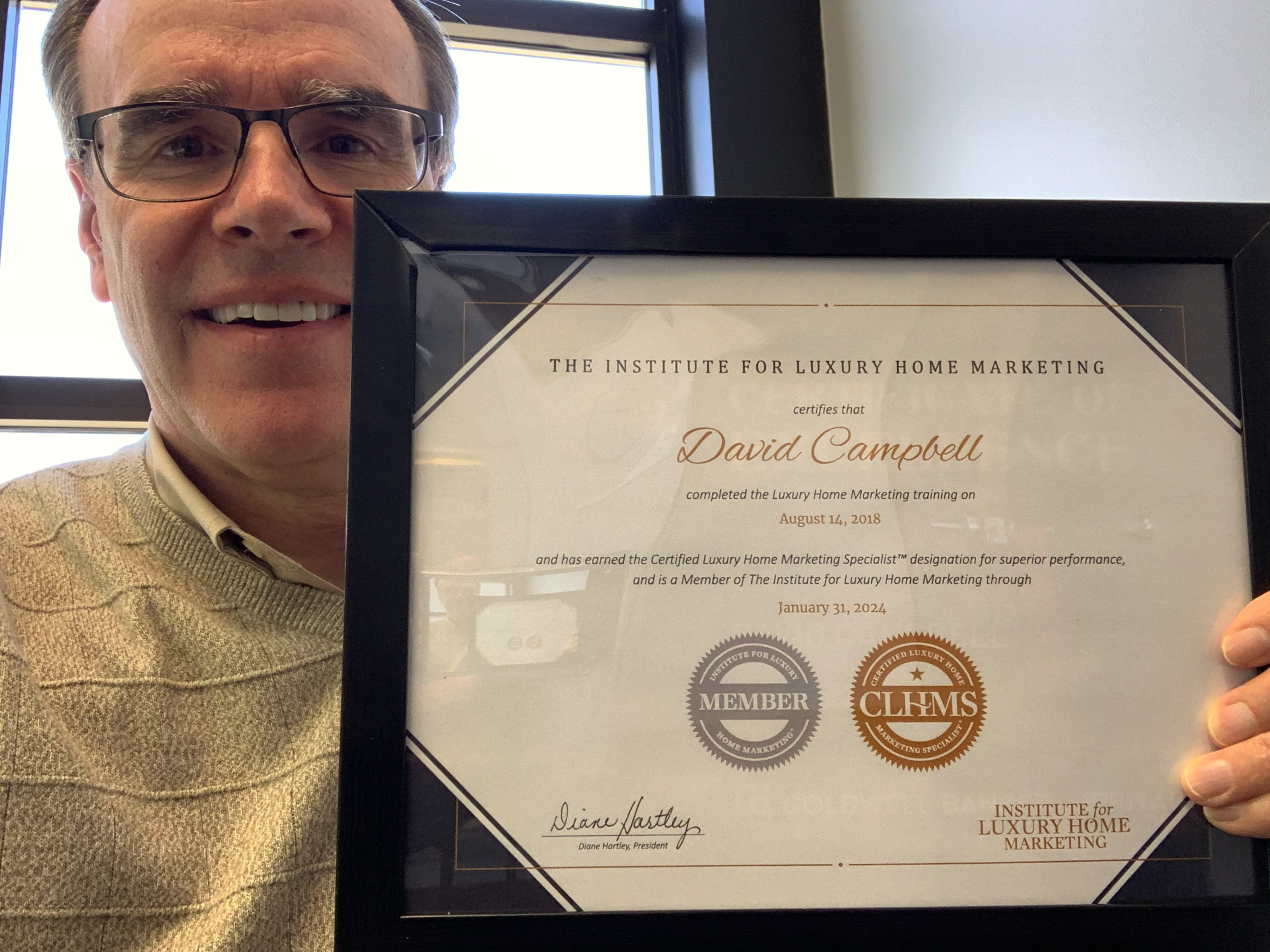 David Campbell, realtor is holding up a certificate that's titled: "The Institute For Luxury Home Marketing"