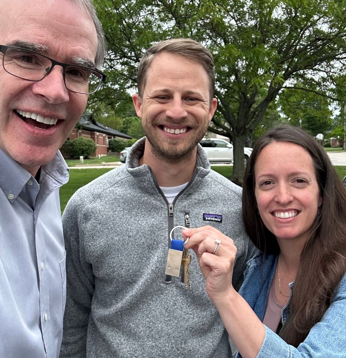 David Campbell, local Dayton realtor, stands next to both Tim and Hali, as Hali holds up a set of modern house keys.