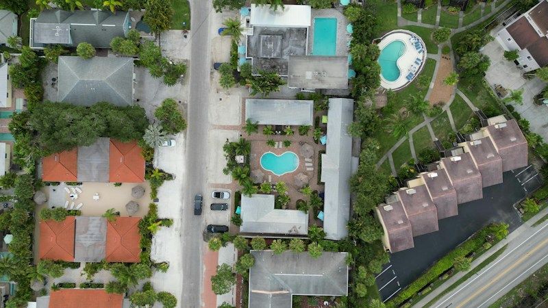 Overhead aerial view of tile roof homes, swimming pools and palm trees in a South Florida neighborhood
