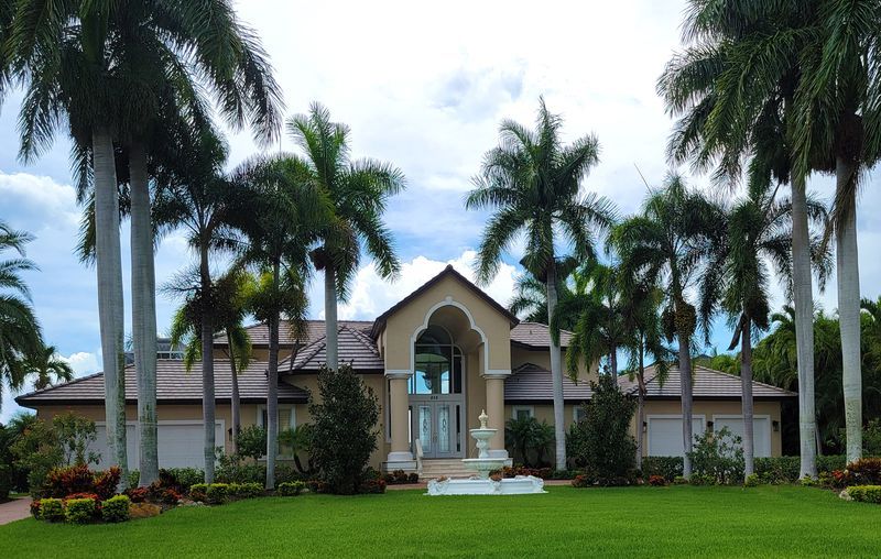 Single-family home with a tile roof and royal palms in Boca Raton