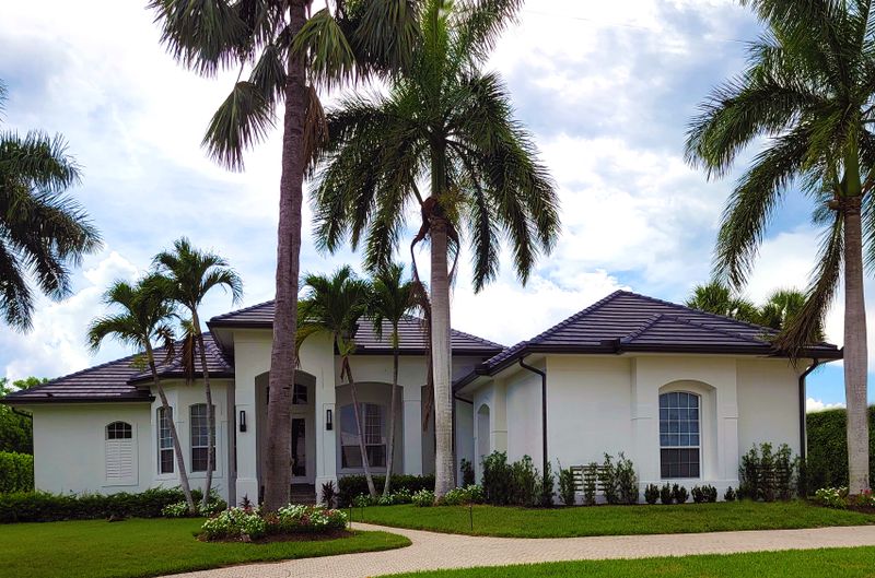 Boca Raton home with a tile roof and mature palms, priced for the current market