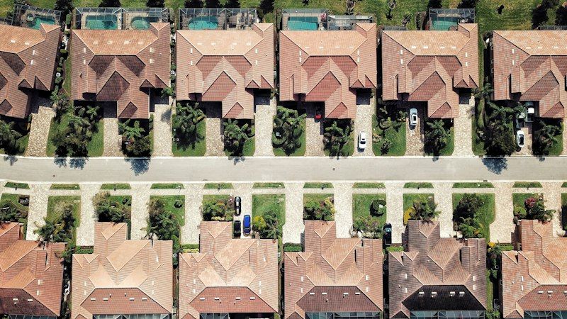 Aerial view of tile roof houses with screened pools in a South Florida neighborhood like many in Boca Raton