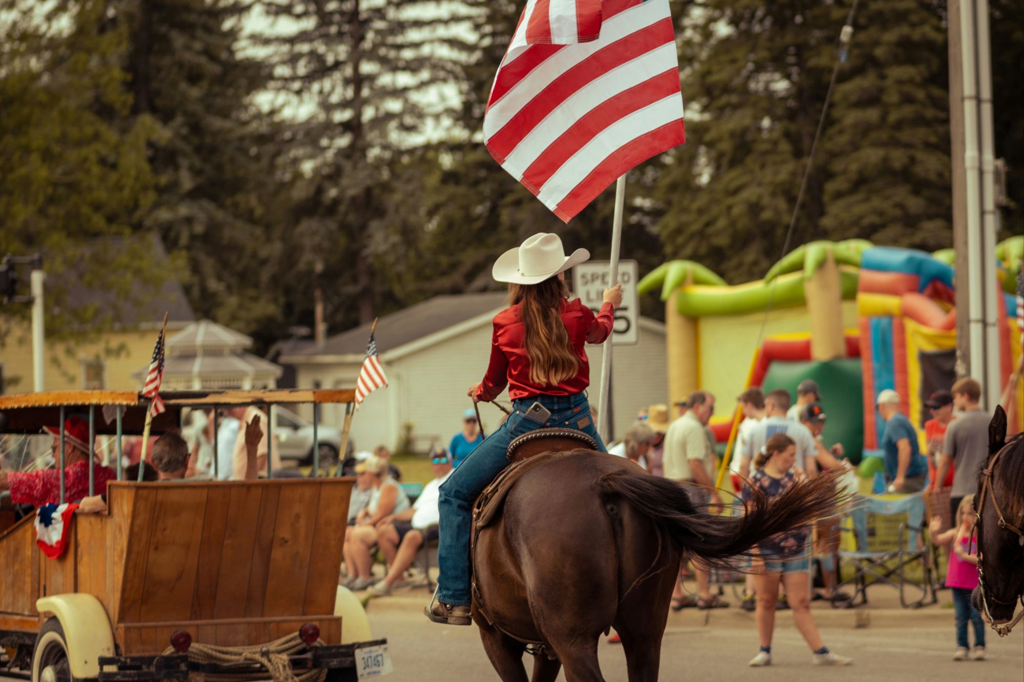 Small-town Fourth of July parade with families marching and waving American flags