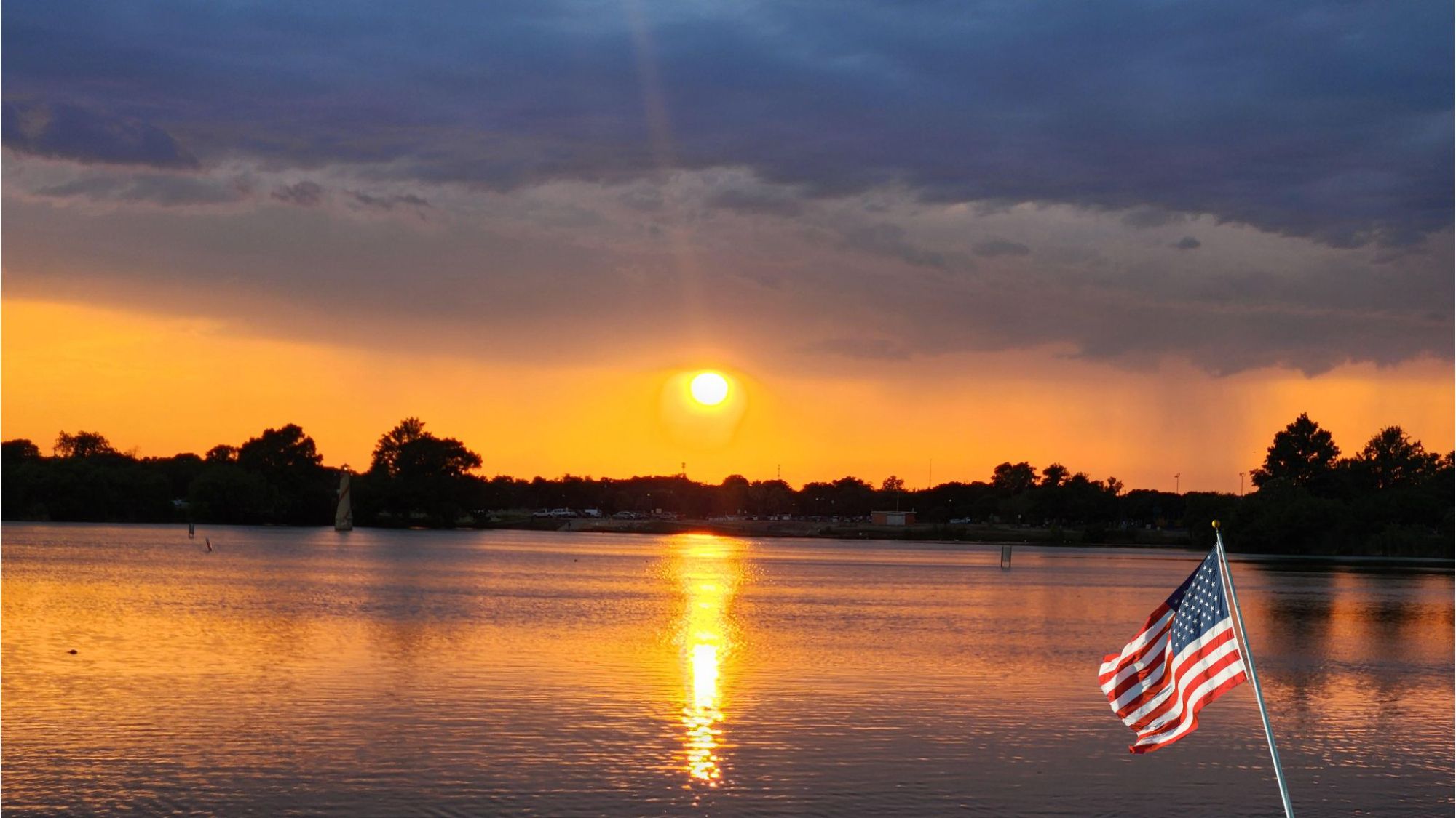 Sunrise over Woodlawn Lake San Antonio with American flag in foreground