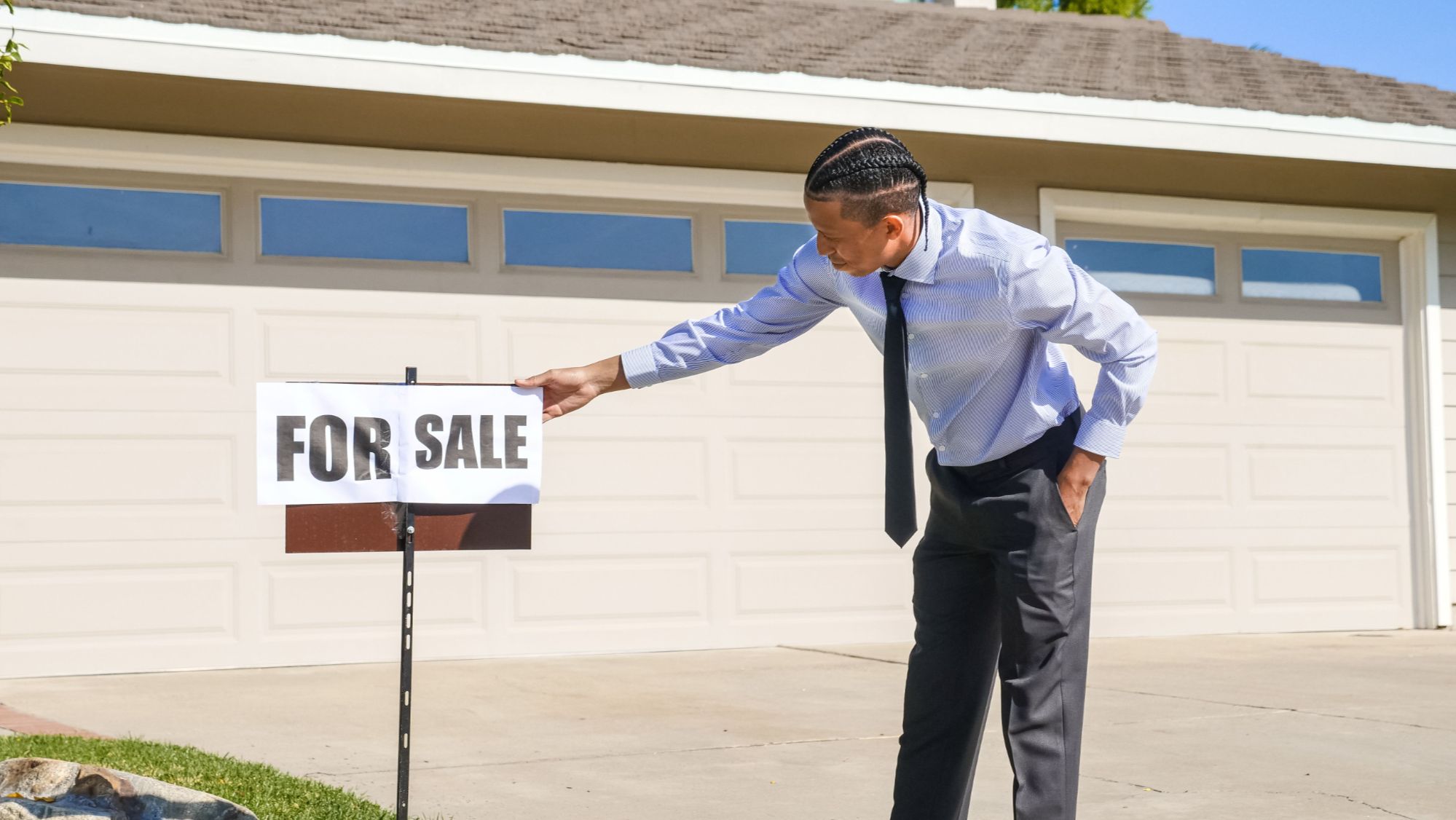 Agent placing a for-sale sign as the 2026 San Antonio market shifts toward buyers