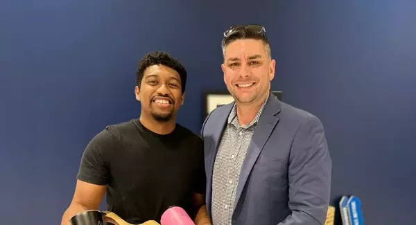 Military service member and Realtor Anthony Sharp holding a welcome-home gift basket after closing on a new home near JBSA Randolph Air Force Base in San Antonio, Texas