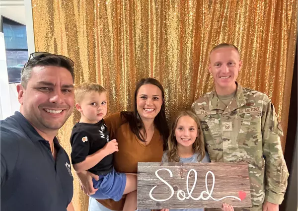 Anthony with happy military family with a sign saying Sold