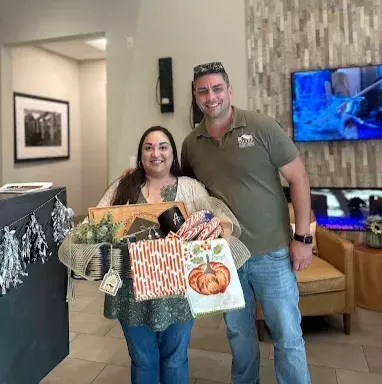 Sharp Realty Group client receives a festive house-warming basket from Anthony Sharp in the lobby after purchasing her home