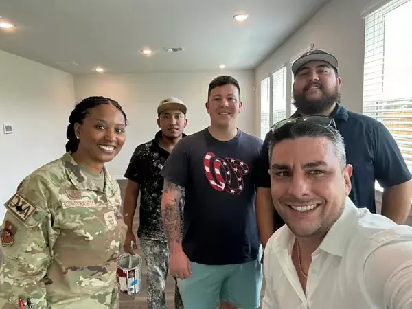Selfie of Anthony Sharp, an Air Force client, and renovation crew during a new-construction walk-through in San Antonio