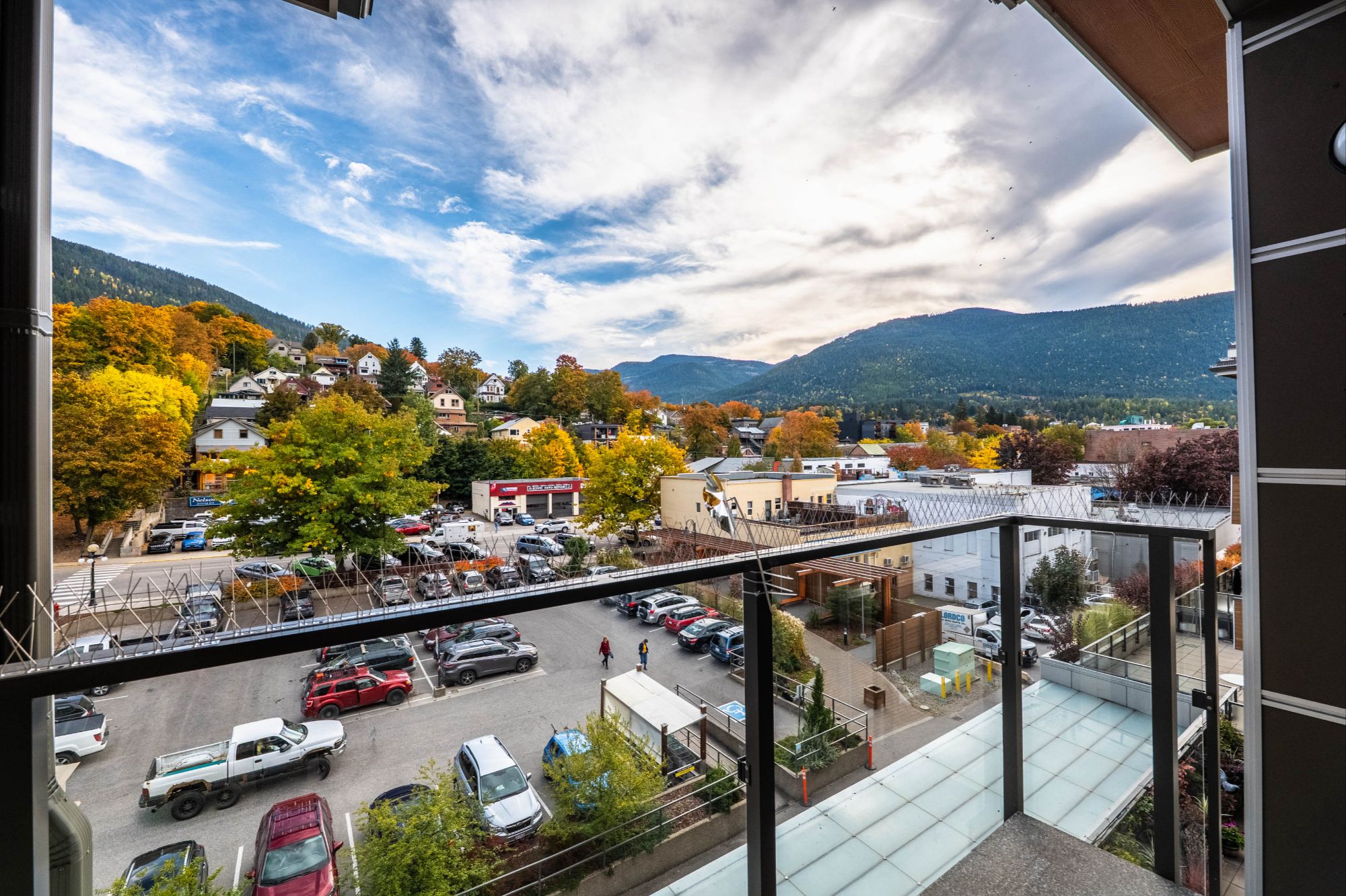 Balcony view from top-floor condo at Nelson Commons, overlooking downtown Nelson BC and surrounding mountains in autumn