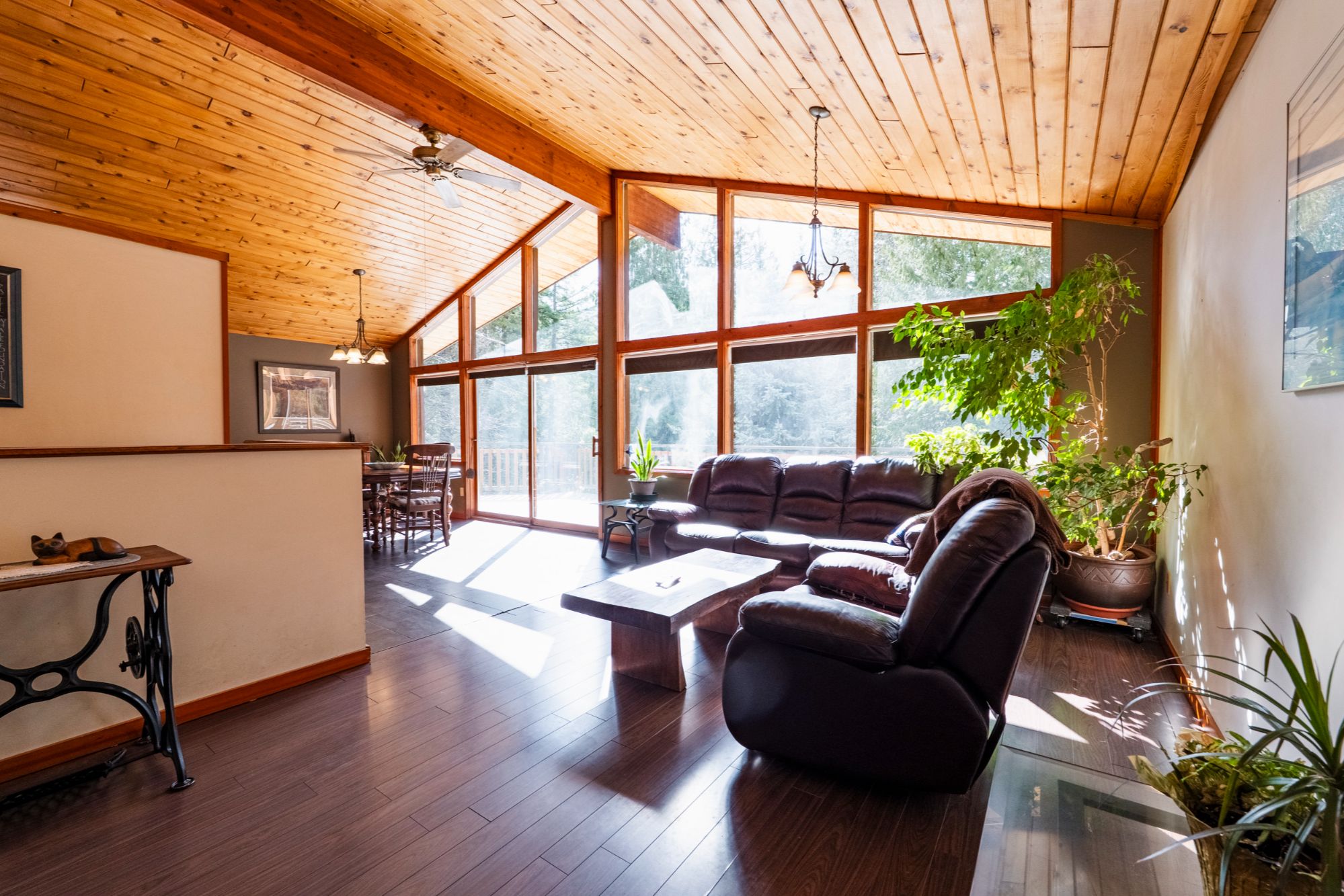 Bright living room with vaulted wood ceilings and floor-to-ceiling windows in Balfour BC home near Nelson