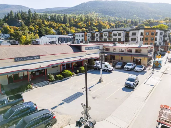 Wide front view of Gateway Building commercial real estate in Nelson BC featuring Kootenai Moon Home, Torchlight Brewing, and parking area