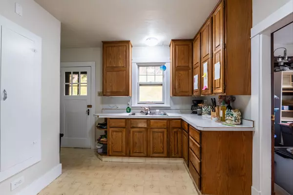 Charming hallway with original hardwood floors, built-in glass cabinet, and vintage wood trim in a multi-unit Nelson BC income property.