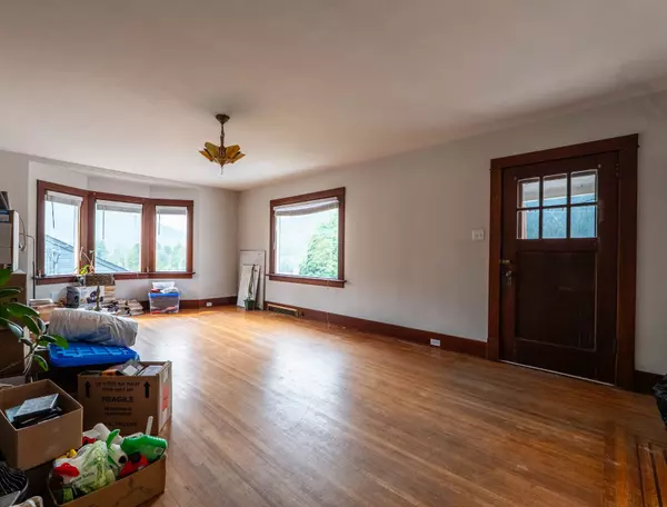 Charming hallway with original hardwood floors, built-in glass cabinet, and vintage wood trim in a multi-unit Nelson BC income property.