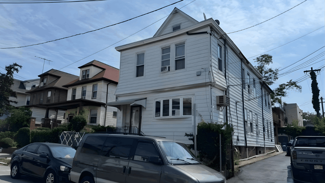 Exterior view of the multi family home at 72-74 Maple St in Paterson NJ showing the white two story structure, driveway, and neighboring houses, used for a real estate investment blog by Johnny Rodriguez.
