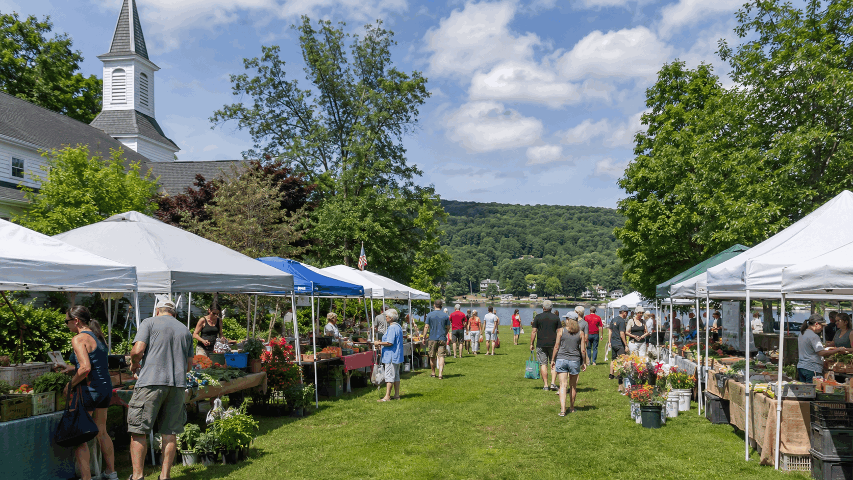West Milford Farmers Market in Passaic County with fresh produce, flowers, local vendors, shoppers, a church setting, open green space, wooded hills, and lake-country scenery on a sunny summer afternoon.