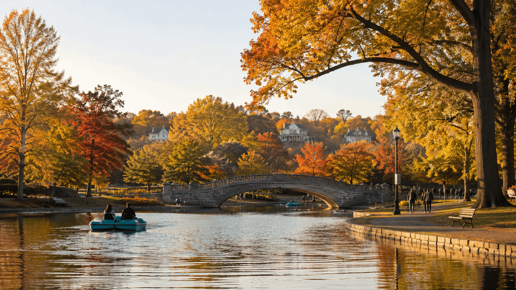 Verona Park in Verona, NJ, with a calm lake, stone bridge, paddleboats, walking paths, and colorful autumn trees.