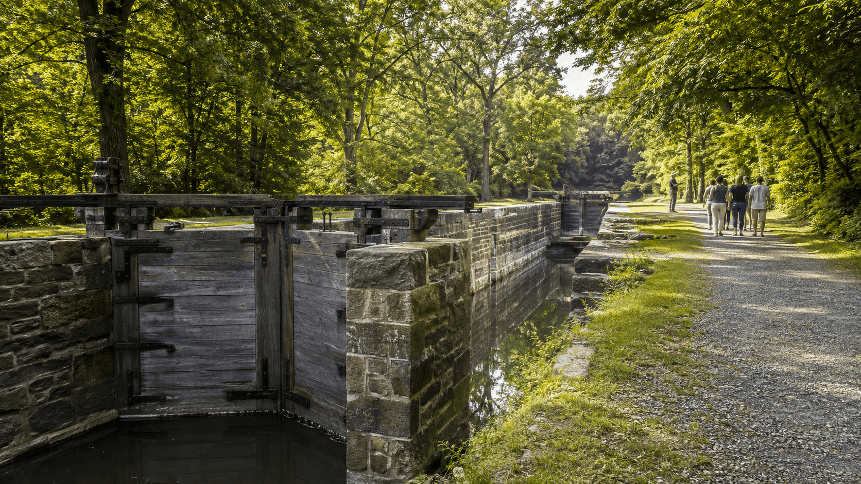 Restored Morris Canal lock at Hugh Force Canal Park in Wharton with stone walls, wooden gates, a towpath and guided visitors.