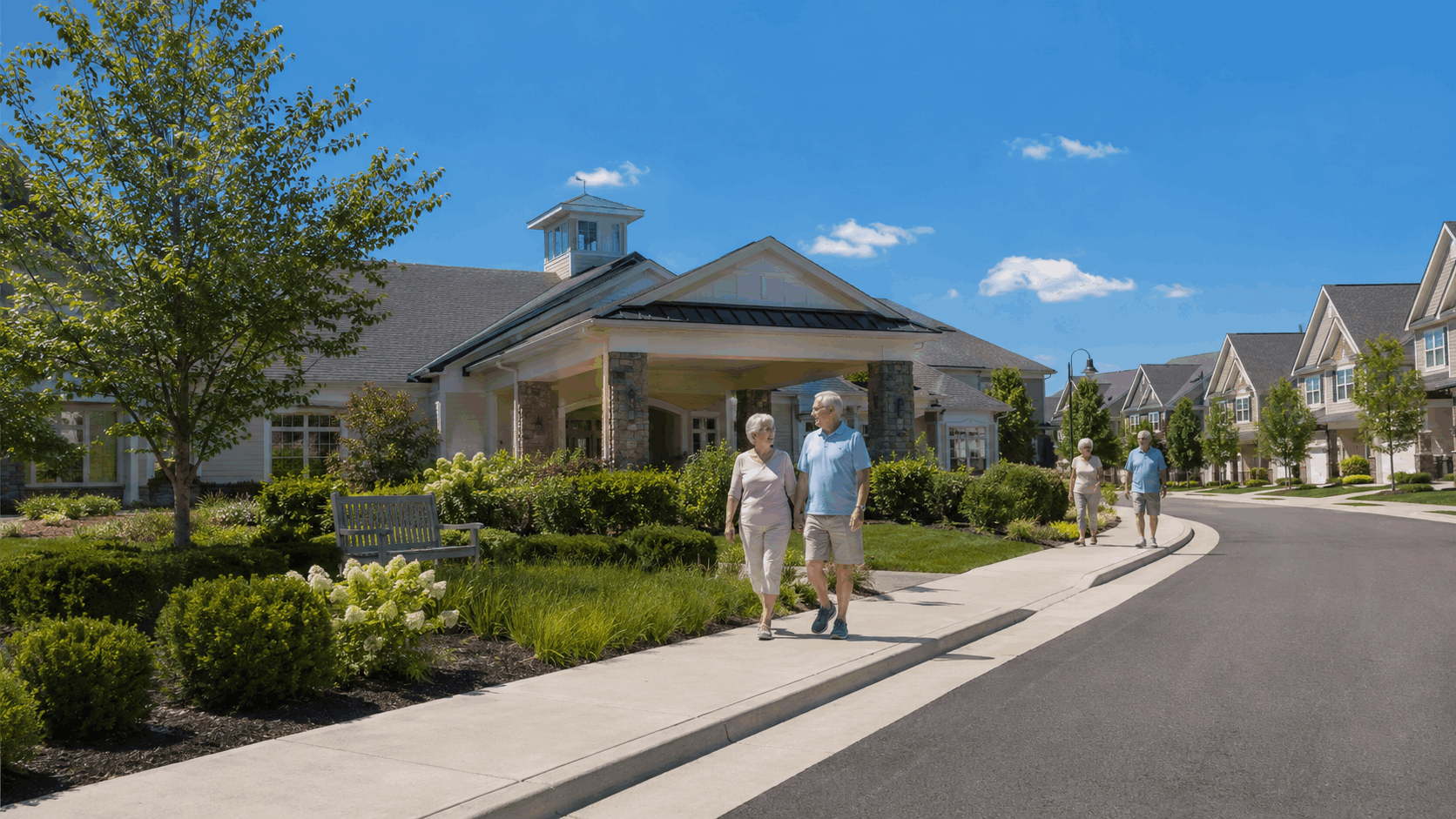 Senior residents walking near a North Jersey 55+ community entrance with townhomes, clubhouse-style architecture, and manicured landscaping.